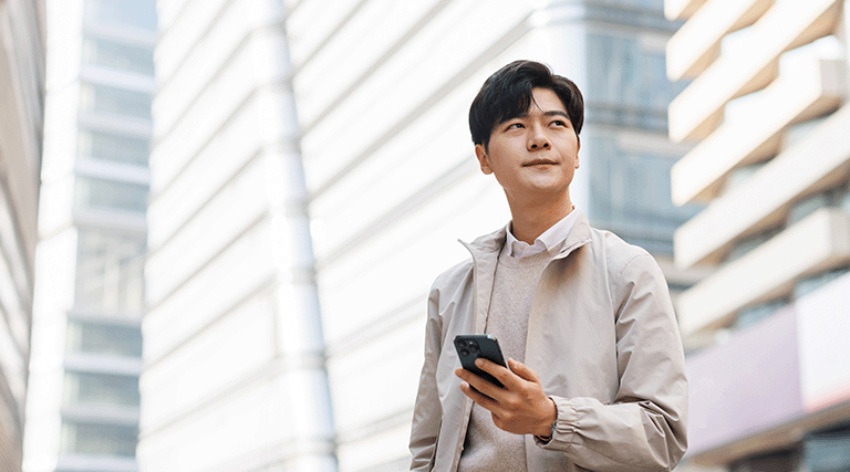 Man holding phone and looking into the distance